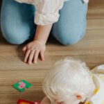 Flashcards - A Woman Kneeling on Floor Watching a Baby Playing with Flashcards
