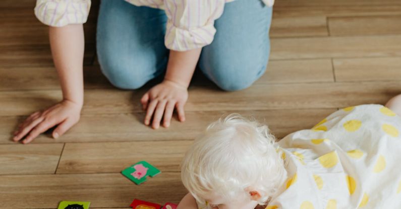 Flashcards - A Woman Kneeling on Floor Watching a Baby Playing with Flashcards