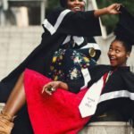 Recent Graduates - Shallow Focus Photography of Two Women in Academic Dress on Flight of Stairs