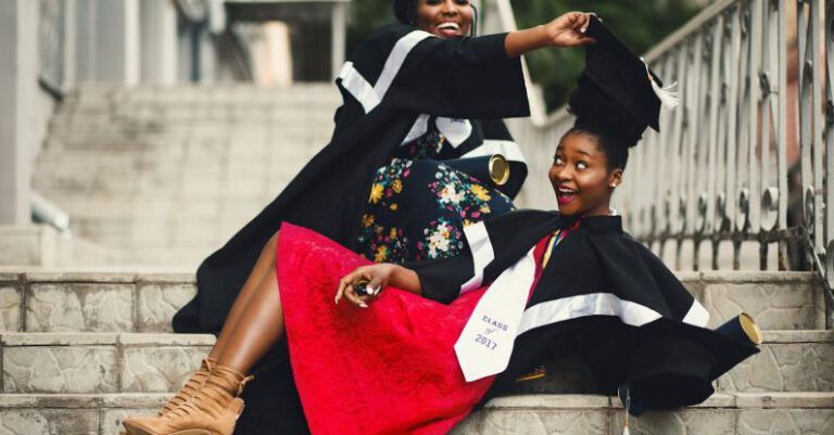 Recent Graduates - Shallow Focus Photography of Two Women in Academic Dress on Flight of Stairs