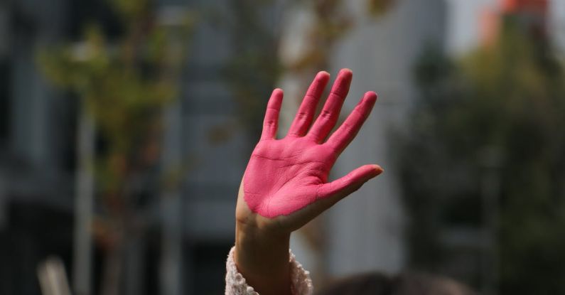 Personal Statement - A person with pink hands holding up their hand